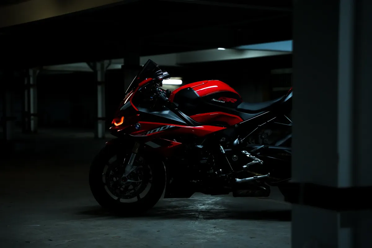 赤いスポーツ自転車が暗い照明の garage に停められていて、そのスリムなデザインと鮮やかな色が際立っています。