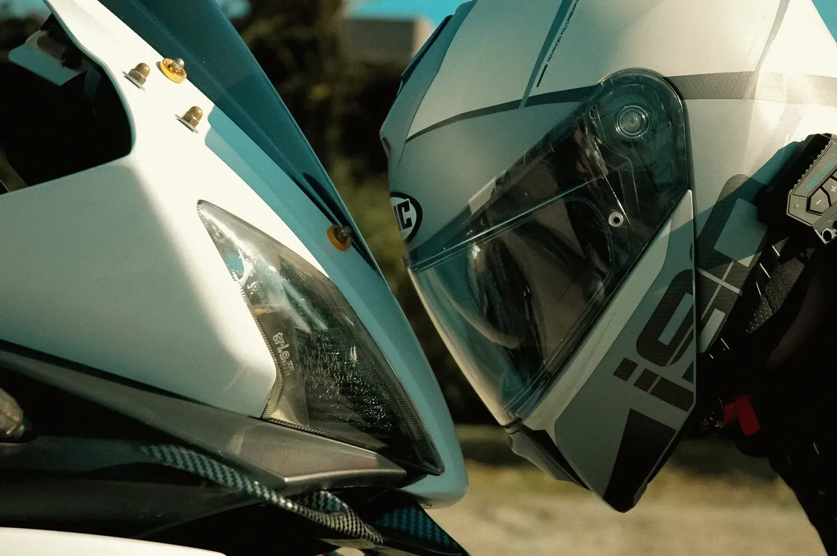 Dynamic close-up of a motorcycle and rider's helmet outdoors, emphasizing speed and adventure.