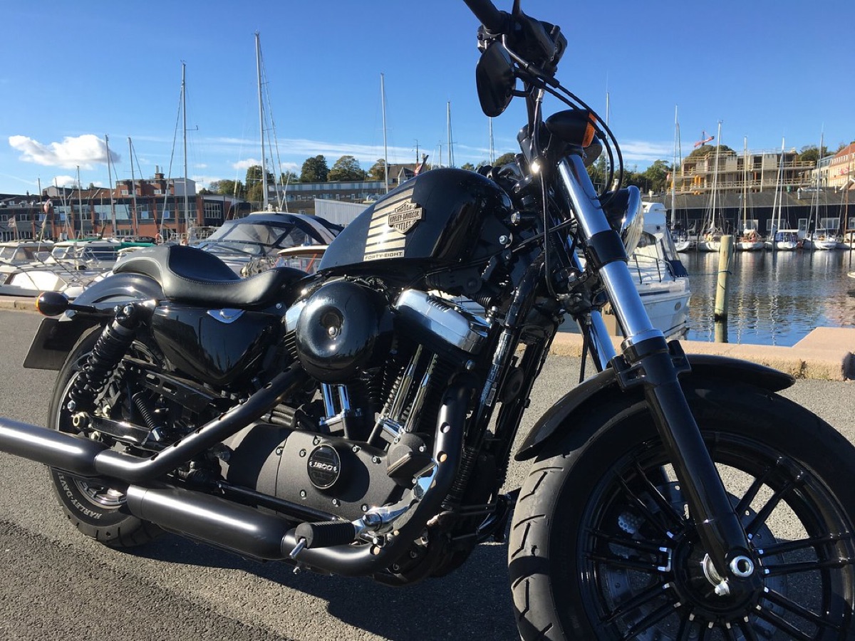 Ein maßgeschneidertes Cruiser-Motorrad auf einer Landstraße bei Sonnenuntergang