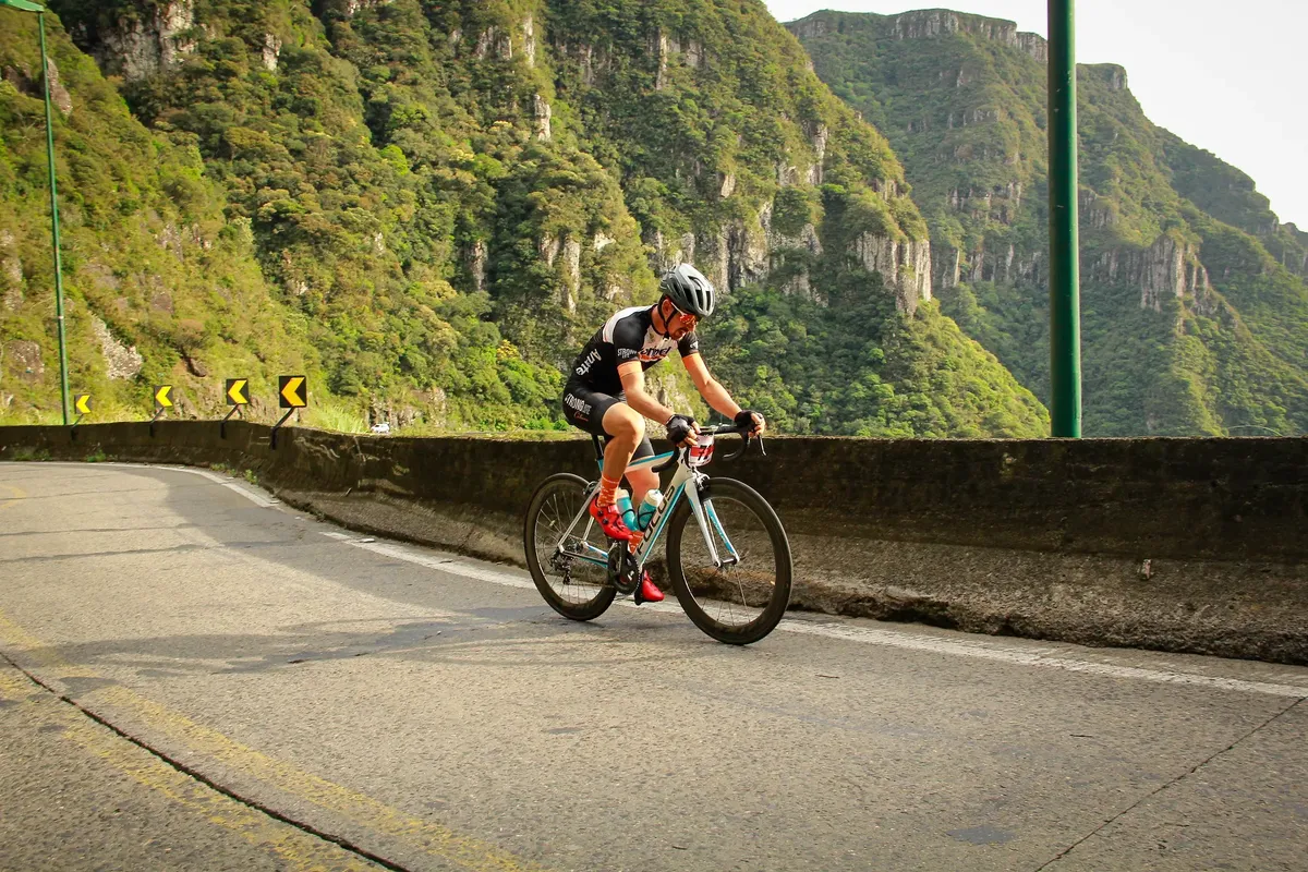 プロアマチュア選手が風景のある山道でレースをしています。集中力とアスリートの姿を表現しています。