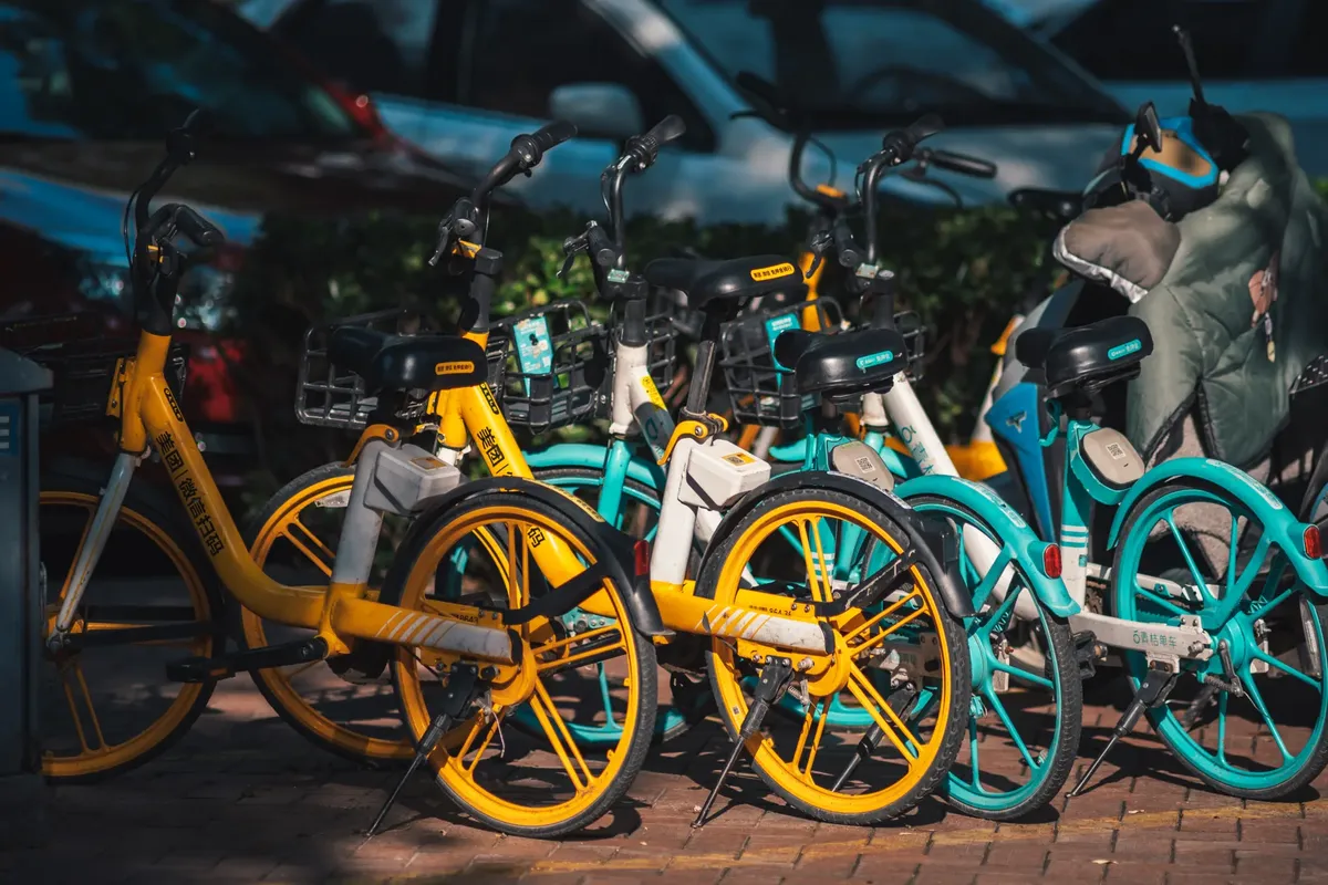 Brightly colored bikes parked in an urban area, highlighting a bike-sharing program.