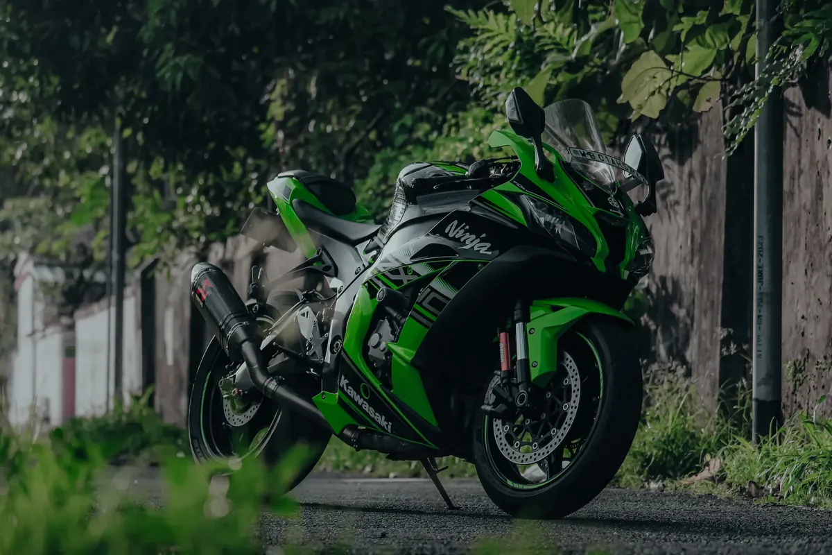 A sleek Kawasaki Ninja ZX-10R motorcycle parked on a lush roadside in India.