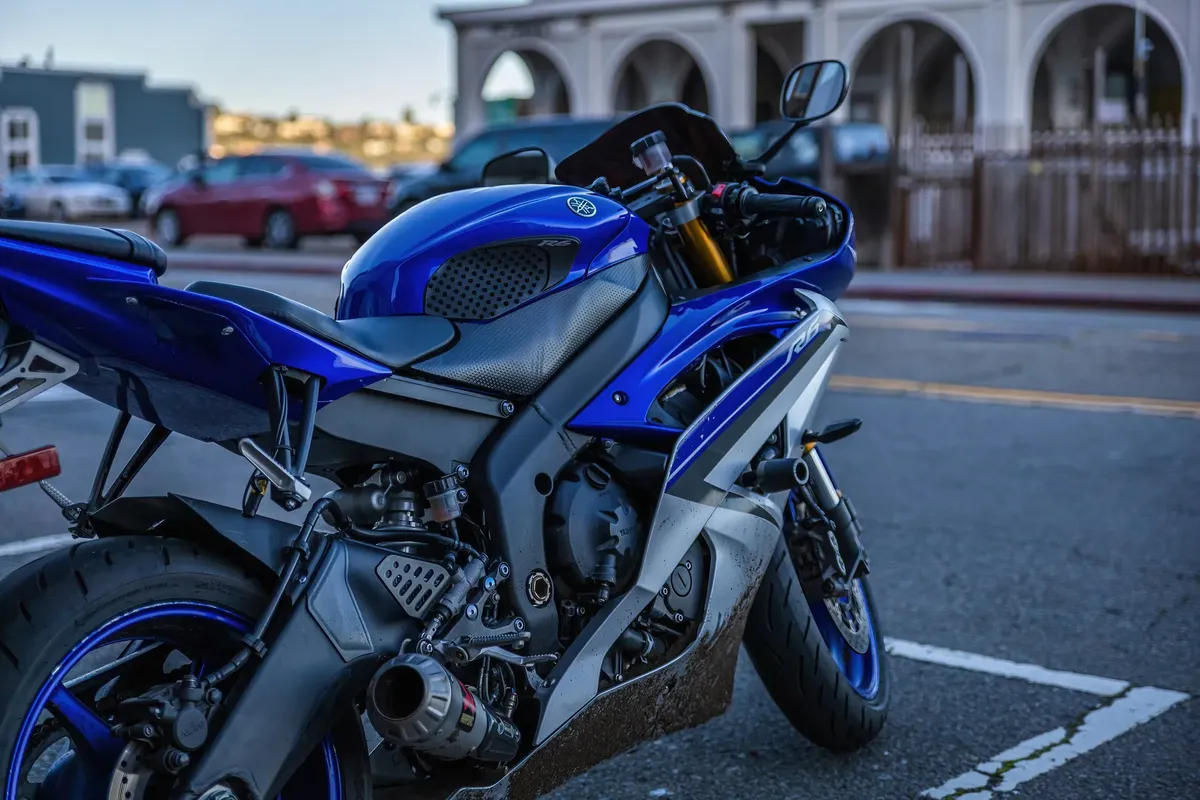 A sporty blue Yamaha YZF-R6 motorcycle parked outdoors, showcasing sleek design.